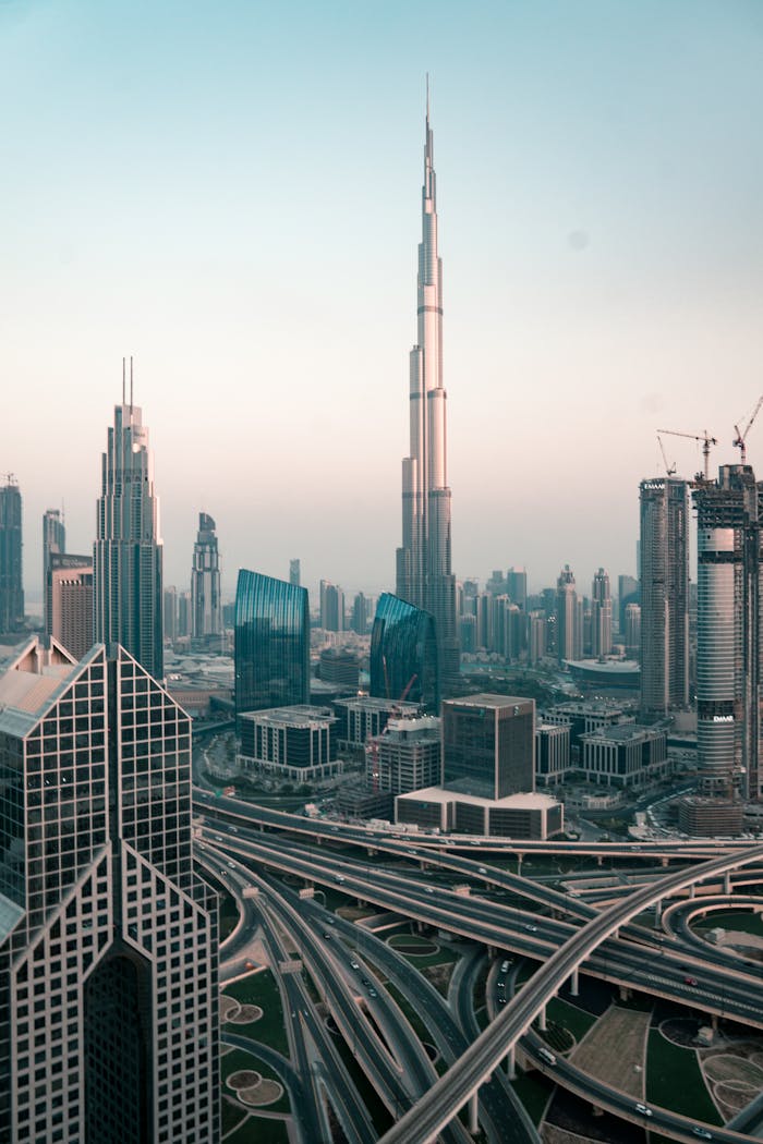 who-we-are Aerial view of Dubai's skyline with Burj Khalifa and intricate highway system at sunset.
